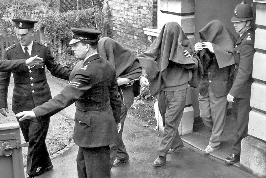 Policajti odvádzajú z budovy súdu páchateľov veľkej vlakovej lúpeže. Proces s nimi trval od januára do apríla 1964 a podľa verdiktu mali odsúdení stráviť vo väzení dovedna 307 rokov.