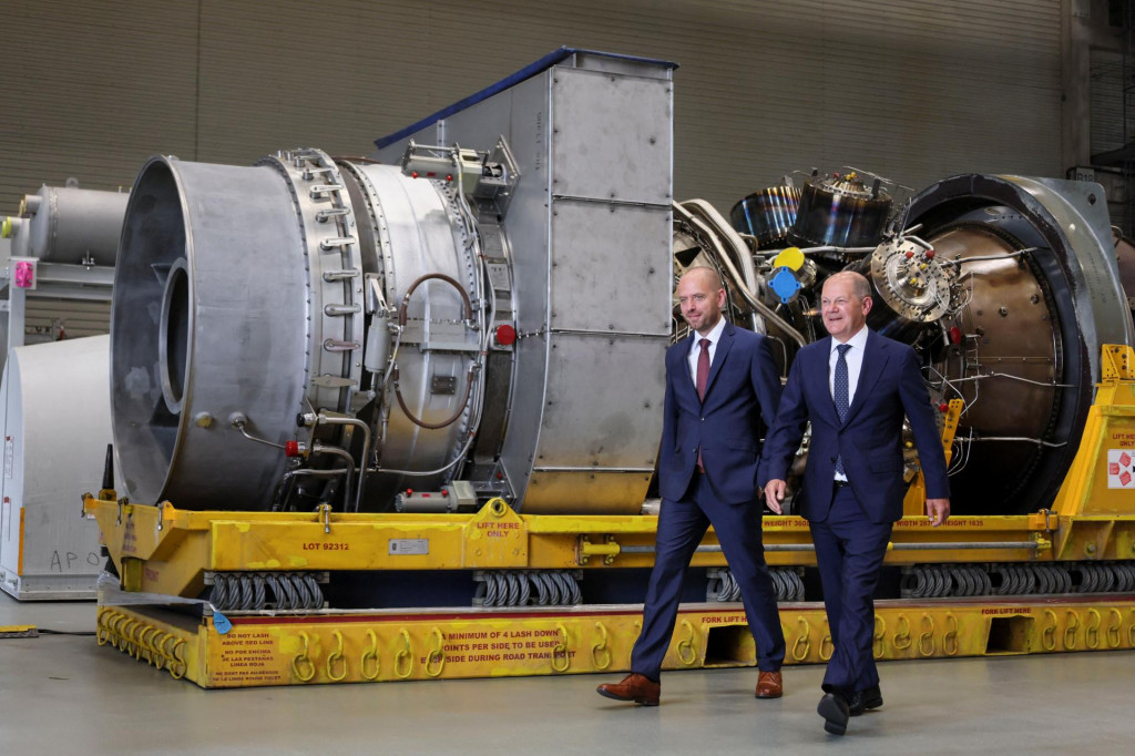 Generálny riaditeľ Siemens Energy Christian Bruch a nemecký kancelár OIaf Scholz kráčajú vedľa plynovej turbíny, ktorá má byť prepravená do kompresorovej stanice Nord Stream 1. FOTO: Reuters
