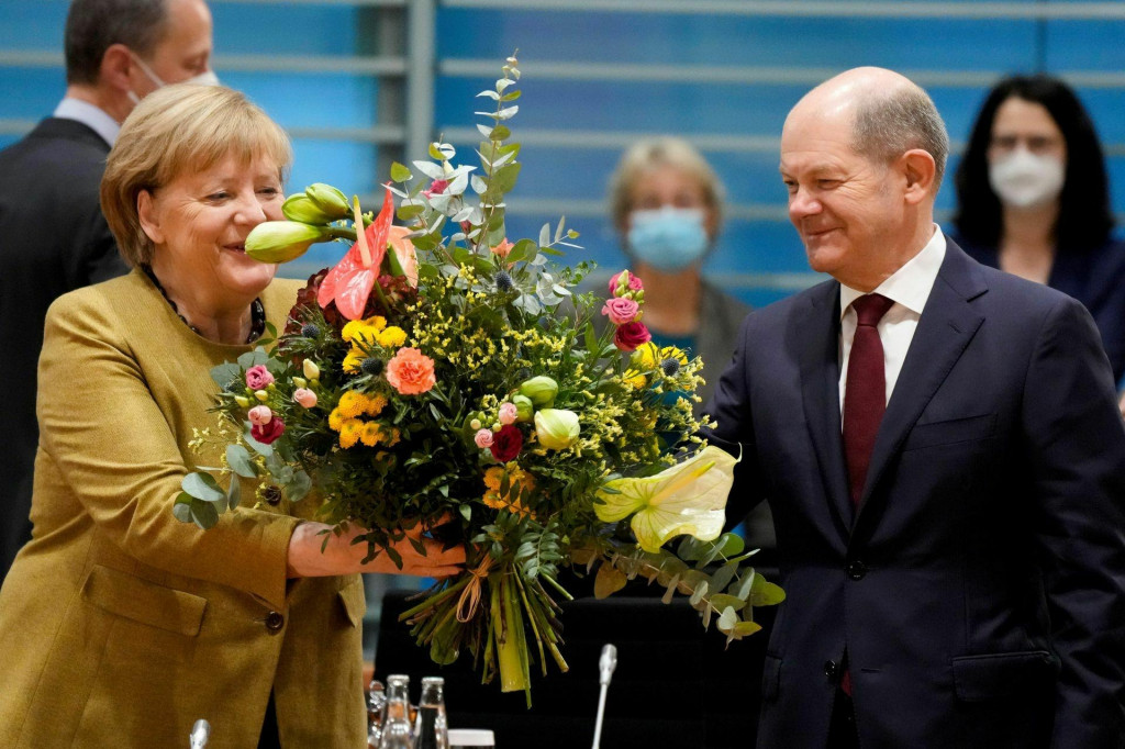 &lt;p&gt;Niekdajšia kancelárka Angela Merkelová preberá kyticu od nemeckého ministra financií, dnešného kancelára Olafa Scholza pred zasadnutím vlády v Berlíne, Nemecko, 24. novembra 2021. FOTO: REUTERS&lt;/p&gt;