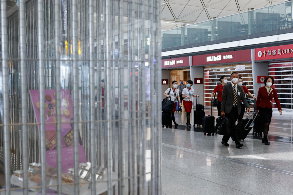 Obsluha Cathay Pacific kráča popri dočasne zatvorených obchodoch v odletovej hale medzinárodného letiska v Hongkongu. FOTO: Reuters