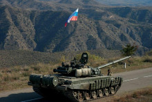 Služobný člen ruských mierových jednotiek vedľa tanku neďaleko hranice s Arménskom po podpísaní dohody o ukončení vojenského konfliktu medzi Azerbajdžanom a etnickými arménskymi silami v regióne Náhorný Karabach, 10. novembra 2020. FOTO: REUTERS