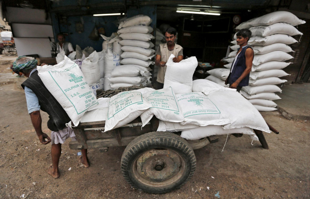 Robotník v Indii vykladá vrecia s cukrom na trhovisku v Ahmedabade. FOTO: Reuters
