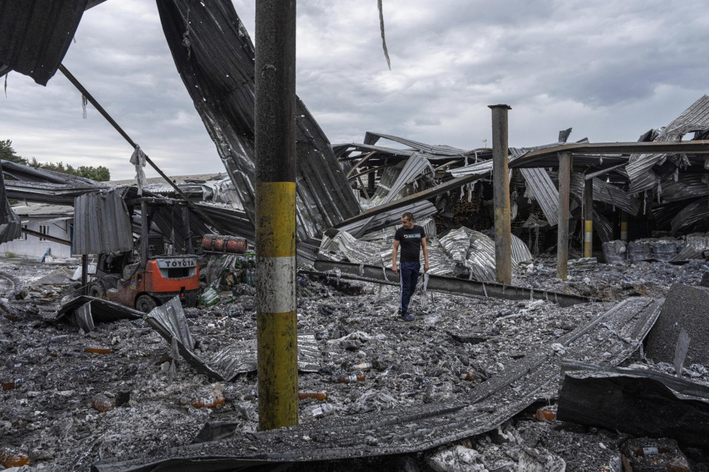 Miestny obyvateľ Olexander prehľadáva svoju fabriku na výrobu nápojov, ktorá bola zničená ruskou raketou minulú noc v Charkovskej oblasti. FOTO: TASR/AP