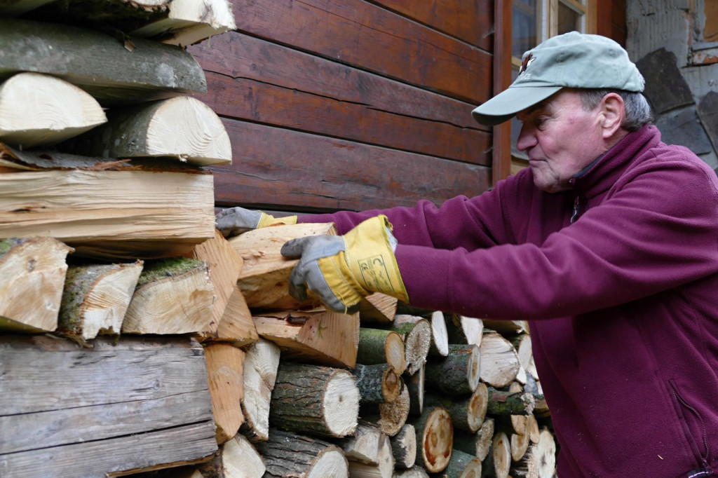 Muž ukladá drevo na zimu na chalupe v obci Strečno. FOTO: TASR/E. Ďurčová