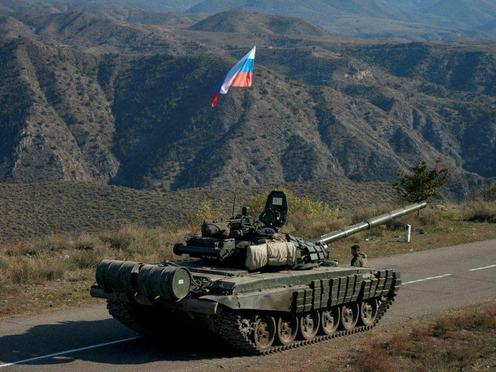 Služobný člen ruských mierových jednotiek vedľa tanku neďaleko hranice s Arménskom po podpísaní dohody o ukončení vojenského konfliktu medzi Azerbajdžanom a etnickými arménskymi silami v regióne Náhorný Karabach, 10. novembra 2020. FOTO: REUTERS