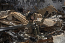 Člen práporu Karpatský Sich, prechádza zničenou budovou, na fronte v Charkovskej oblasti na Ukrajine, 1. júla 2022. FOTO: REUTERS