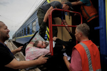 Oleksandra Sugachova (55), ktorý utrpel mozgovú príhodu z Bakhmutu, pomáhajú naložiť do vlaku smerujúceho do Dnipra a Ľvova počas evakuácie z oblastí východnej Ukrajiny postihnutých vojnou, 5. august 2022. FOTO: REUTERS