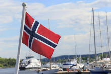 Nórska vlajka vlaje na lodi v Aker Brygge v Osle. FOTO: Reuters