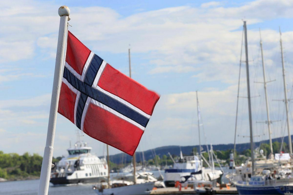 Nórska vlajka vlaje na lodi v Aker Brygge v Osle. FOTO: Reuters