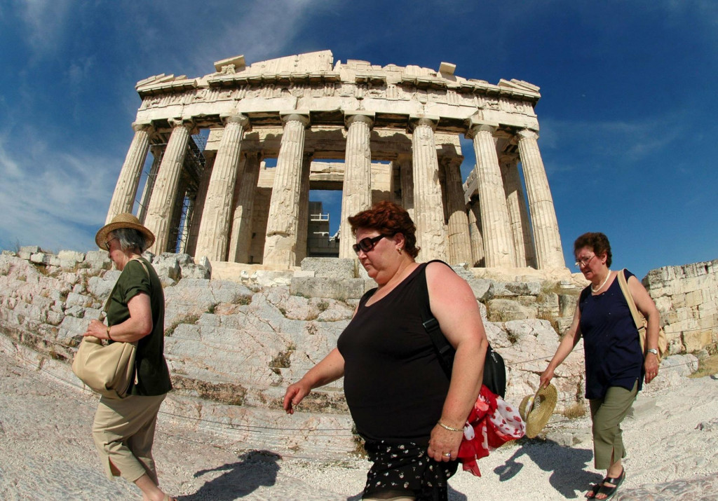 Turisti prechádzajú popred chrám Partenón na aténskej Akropole. FOTO: TASR/Radovan Stoklasa
