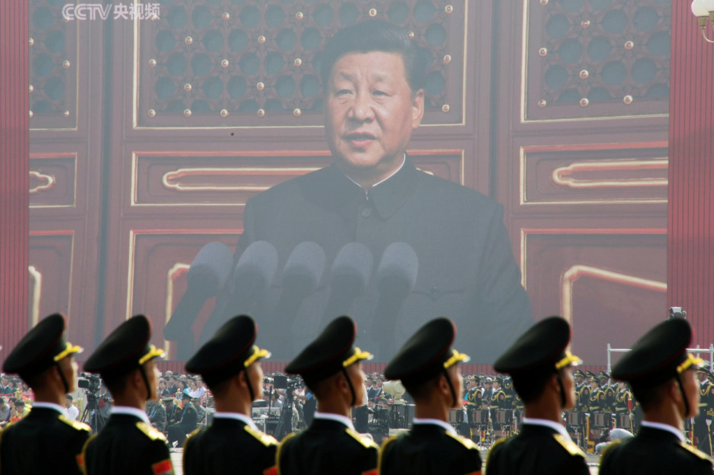 Čínski vojaci stoja pred obrovskou obrazovkou, z ktorej k nim prehovára prezident Si Ťin-pching. FOTO: Reuters