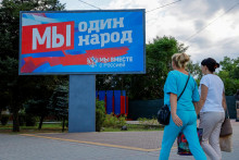 &lt;p&gt;Ženy kráčajú okolo bilbordu s proruskými sloganmi v znení ”Sme jeden národ” v Ruskom okupovanom  meste Melitopol v Záporožskej oblasti na Ukrajine 3. augusta 2022. FOTO: REUTERS&lt;/p&gt;