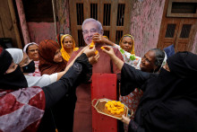 Moslimské ženy ponúkajú sladkosti kartónovému výrezu indického premiéra Narendru Modiho na oslavu v predvečer hinduistického festivalu Raksha Bandhan. FOTO: Reuters