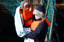 

Migrantka nesie svoje dieťa pri vyloďovaní z lode pohraničných síl do prístavu Dover. FOTO: Reuters