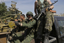 Proruskí rebeli sedia v aute so zbraňami v ukrajinskom meste Doneck. FOTO: TASR/AP