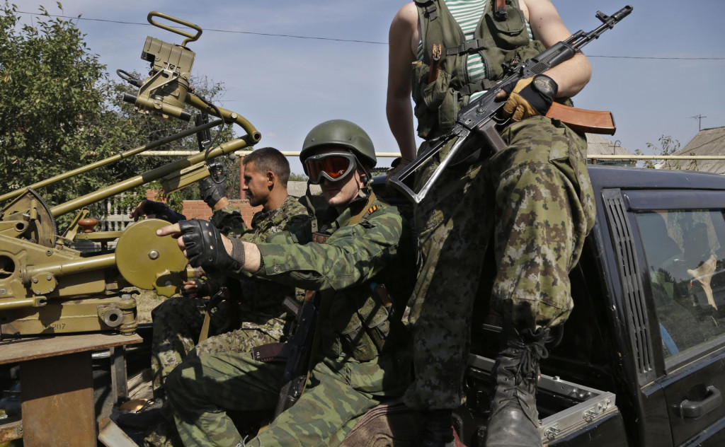 Proruskí rebeli sedia v aute so zbraňami v ukrajinskom meste Doneck. FOTO: TASR/AP