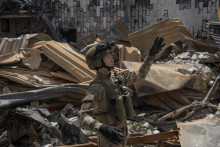Teren, príslušník práporu Karpatský Sich, prechádza zničenou budovou na fronte v Charkovskej oblasti na Ukrajine, 1. júla 2022. FOTO: REUTERS