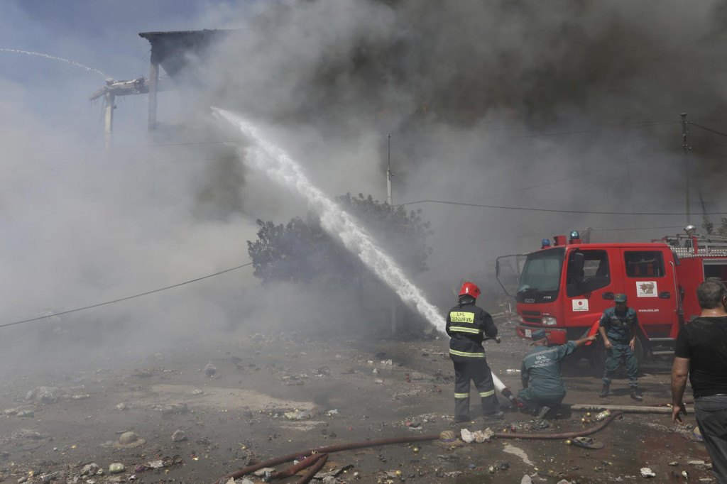 Hasiči hasia plamene pri požiari v obchodnom centre v arménskom meste Surmalu. FOTO: TASR/AP