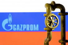 Logo Gazpromu a ruská vlajka v pozadí. FOTO: REUTERS