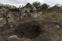 Kráter po ruskom raketovom útoku pri zničených domoch v meste Kramatorsk, na východe Ukrajiny 13. augusta 2022. FOTO: TASR/AP