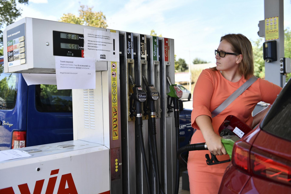 Žena tankuje do svojho auta a číta oznam ”Žiadame vás, aby ste naraz natankovali maximálne 20 litrov benzínu 95” na čerpacej stanici v Budapešti. FOTO: TASR/AP