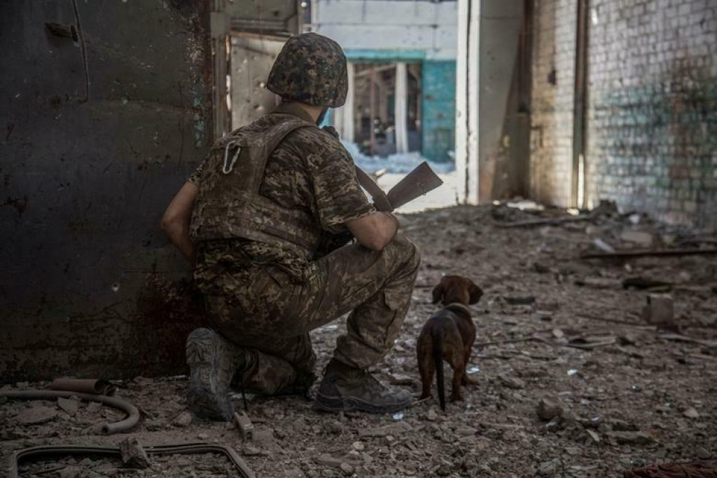 Ukrajinský vojak so psom na hliadke v priemyselnej zóne mesta Severodoneck na Ukrajine, 20. júna 2022. FOTO: REUTERS