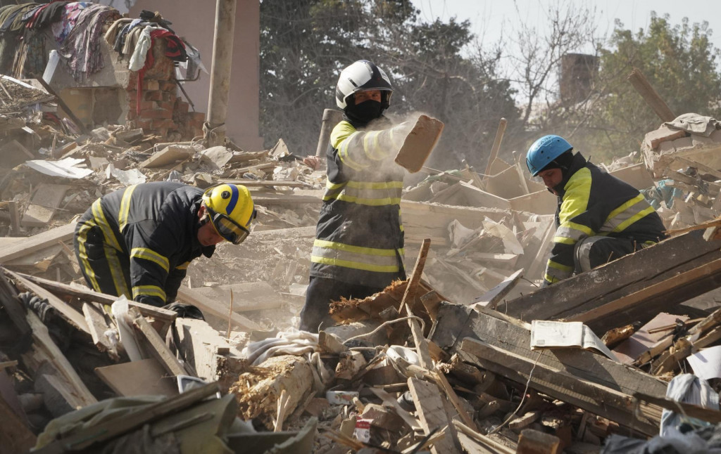 Hasiči prehľadávajú trosky budovy zničenej pri raketovom útoku v druhom najväčšom ukrajinskokm meste Charkov počas 178. dňa ruskej invázie na Ukrajinu vo štvrtok 18. augusta 2022. FOTO: TASR/AP