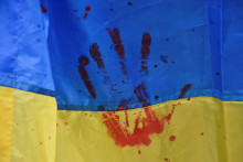 Fotografia ukrajinskej vlajky s krvavým odtlačkom ruky znázorňujúcim agresiu ruských okupantov. FOTO: REUTERS