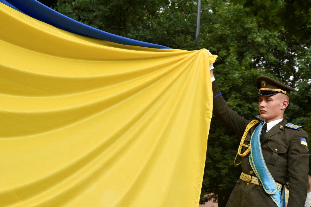 Člen Čestnej str&aacute;že drž&iacute; &scaron;t&aacute;tnu vlajku počas sl&aacute;vnostn&eacute;ho vyst&uacute;penia pri pr&iacute;ležitosti Dňa ukrajinskej &scaron;t&aacute;tnosti uprostred rusk&eacute;ho &uacute;toku na Ukrajinu v Ľvove na Ukrajine 28. j&uacute;la 2022. FOTO: REUTERS