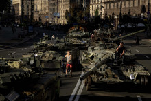 Ľudia prechádzajú okolo zničených ruských vojenských vozidiel v centre Kyjeva. FOTO: TASR/AP


