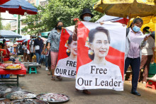 Demonštranti kráčajú tržnicou s transparentmi s podobizňou zosadenej mjanmarskej líderky Aun Schan Su Ťij v Rangúne. FOTO: TASR/AP