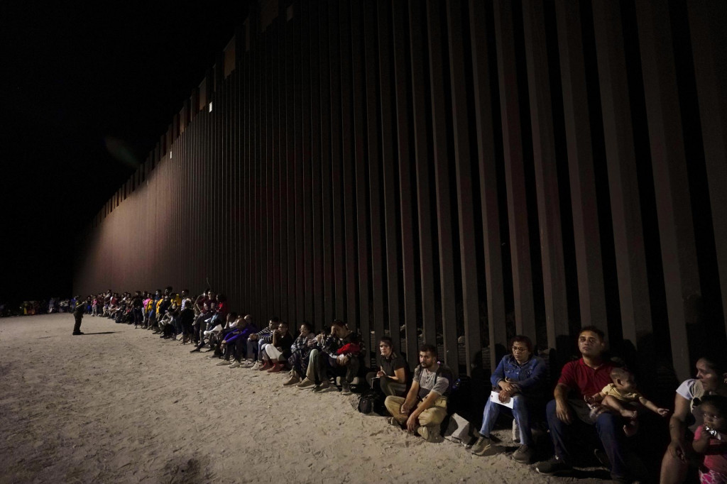 Migranti čakajú pri hraničnom múre. FOTO: TASR/AP