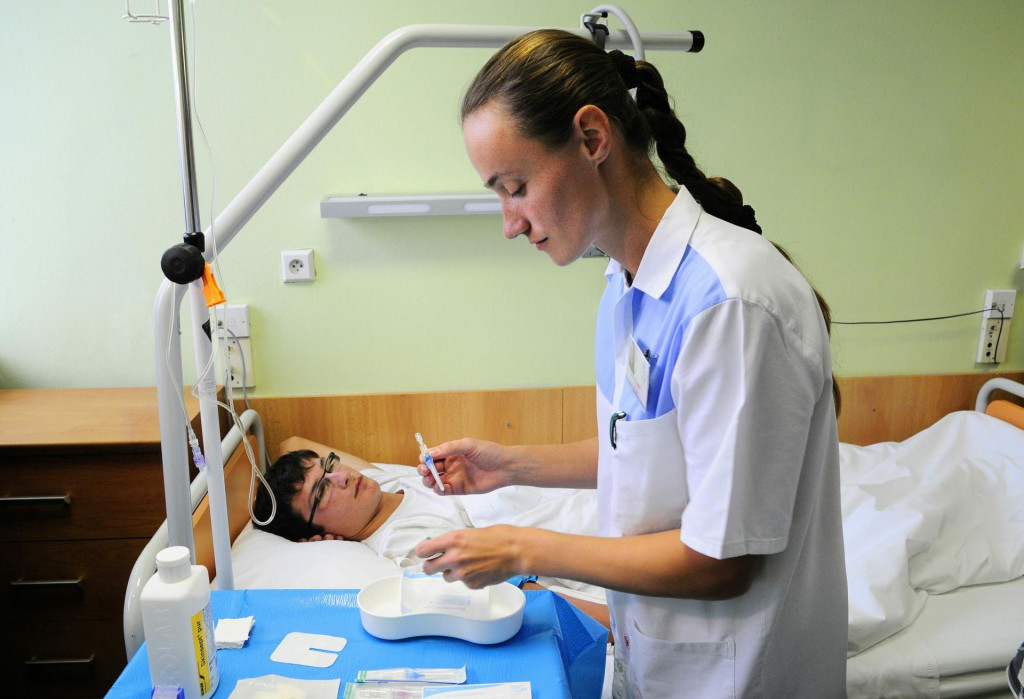 Zdravotná sestra z oddelenia urológie pripravuje bezpečnostnú kanylu pred napichnutím pacientovej žily na napojenie infúzneho roztoku. FOTO: TASR/Milan Kapusta