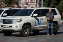Člen misie Medzinárodnej agentúry pre atómovú energiu, ktorá má navštíviť jadrovú elektráreň Záporoží, pri vozidle OSN neďaleko hotela v centre Kyjeva. FOTO: REUTERS