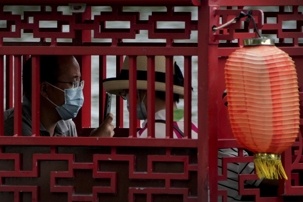 Obyvatelia Číny s ochrannými rúškami proti koronavírusu v Pekingu. FOTO: TASR/AP