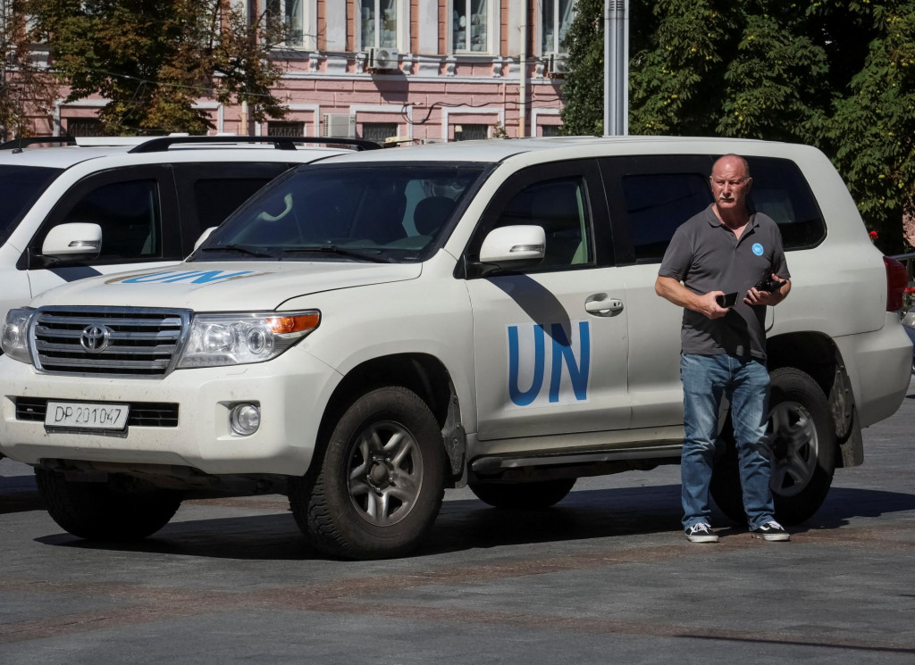 Člen misie Medzinárodnej agentúry pre atómovú energiu, ktorá má navštíviť jadrovú elektráreň Záporoží, pri vozidle OSN neďaleko hotela v centre Kyjeva. FOTO: REUTERS