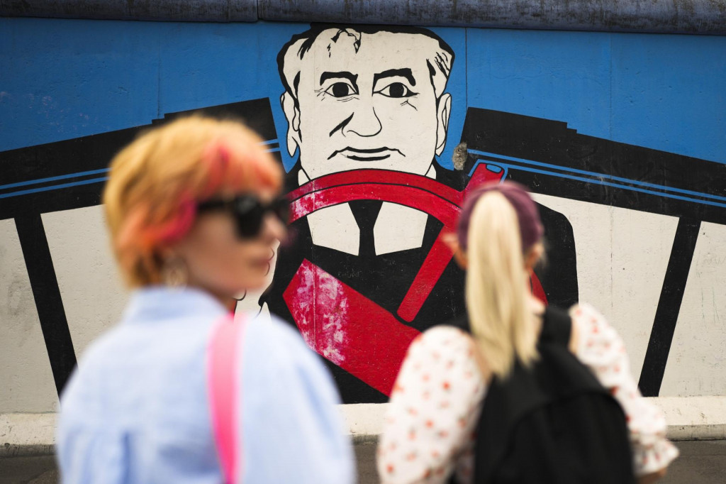 Ženy stoja pred múrom s bývalým prezidentom ZSSR Michailom Gorbačovom. FOTO: TASR/AP