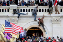 Stúpenci amerického prezidenta Donalda Trumpa bojujú s príslušníkmi orgánov činných v trestnom konaní pri dverách, ktoré sa vylomili, keď zaútočili na budovu Kapitolu USA. FOTO: Reuters