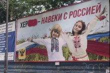 Rusi ukradli fotografiu ukrajinskej fotografky s jej synom a jeho priateľom – a vytvorili z toho ruský propagandistický plagát v okupovanom Chersone. FOTO: Reuters