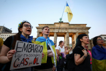 Demonštrant drží v Berlíne transparent s nápisom: „Embargo na ruský plyn a ropu“. FOTO: REUTERS
