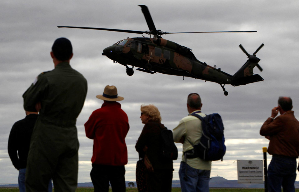 Ľudia sledujúci odlet vrtuľníka. FOTO: Reuters
