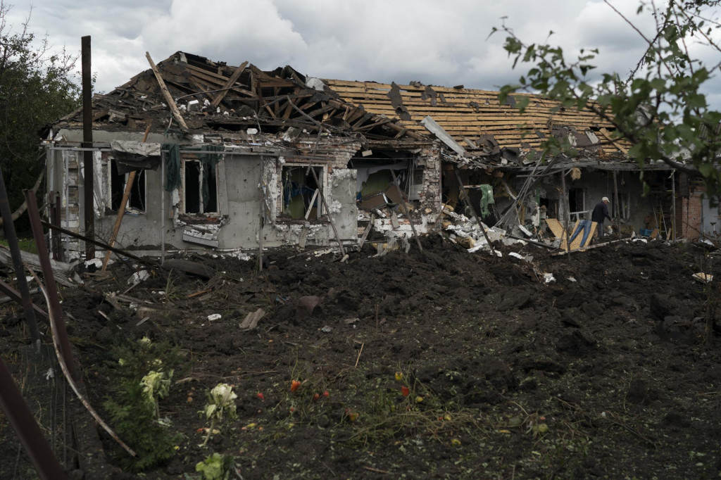 Muž kráča okolo trosiek zničeného domu po ruskom raketovom útoku. FOTO: TASR/AP