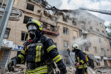 Hasiči počas zásahu v budove, ktorú v Charkove zasiahlo ruské ostreľovanie. FOTO: Reuters