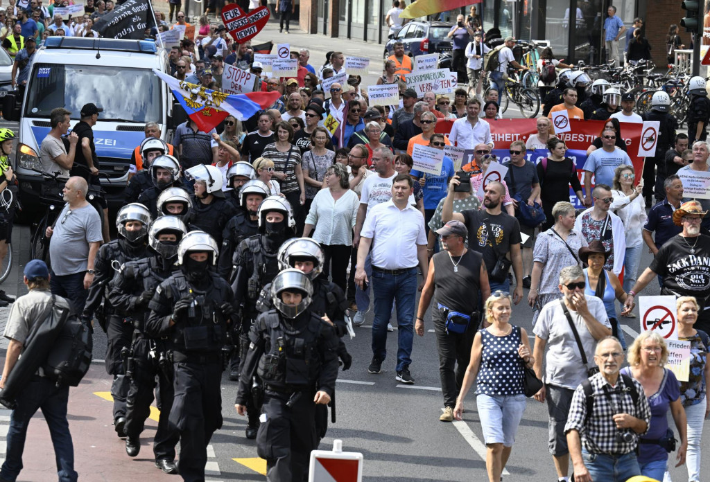 Policajti dohliadajú na účastníkov proruského zhromaždenia pochodujúcich ulicami Kolína nad Rýnom. FOTO: TASR/DPA