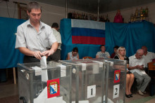 Muž vhadzuje svoje hlasovacie lístky v regionálnych a komunálnych voľbách v Sevestopole. FOTO: TASR/AP