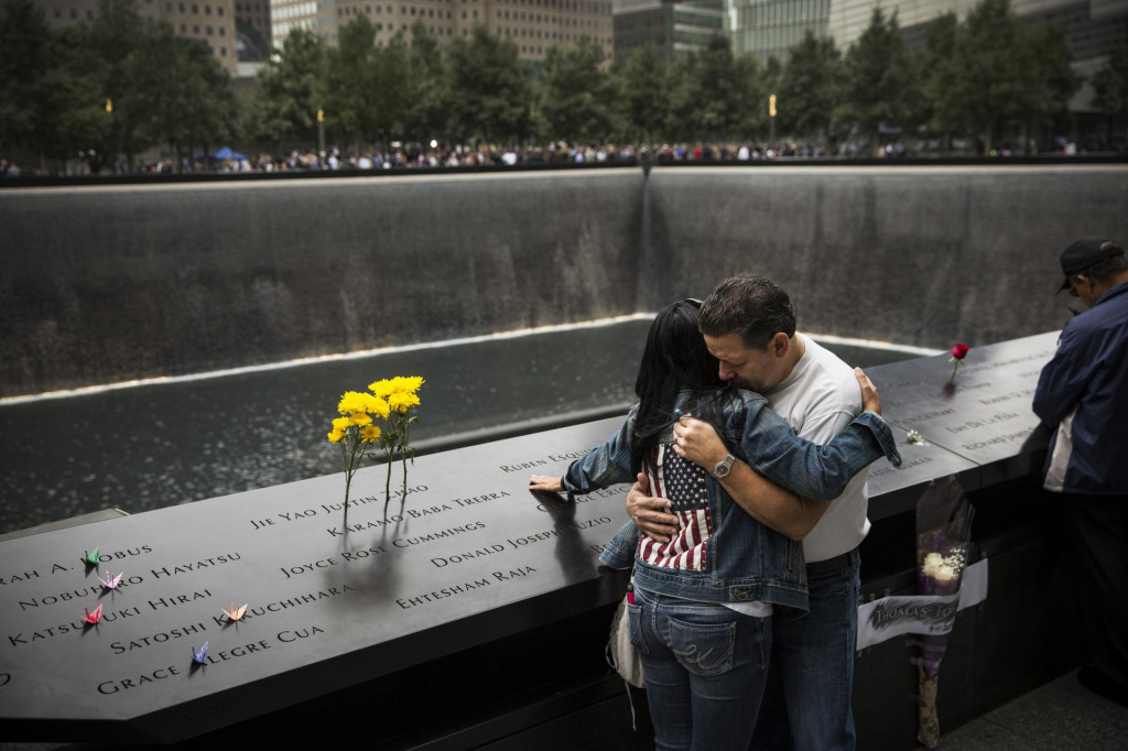 Eileen Esquilinová, ktorá stratila svojho brata sa objíma so svojím manželom Joe Irizarrym pri pamätníku obetí teroristických útokov Svetového obchodného centra. FOTO: TASR/AP