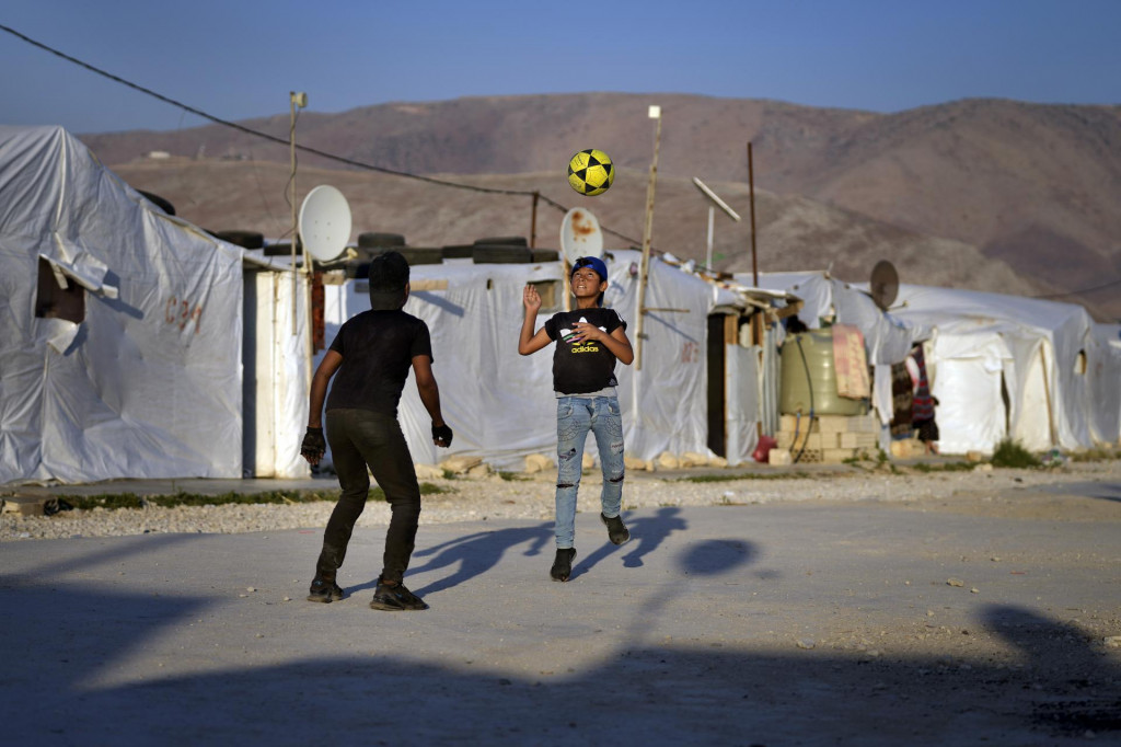 Sýrske deti hrajú futbal neďaleko svojich stanov v utečeneckom tábore v meste Bar Elias na východe Libanonu. FOTO: TASR/AP