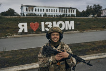 Ukrajinský vojak sa usmieva pred nápisom Milujem Izium. FOTO: TASR/AP
