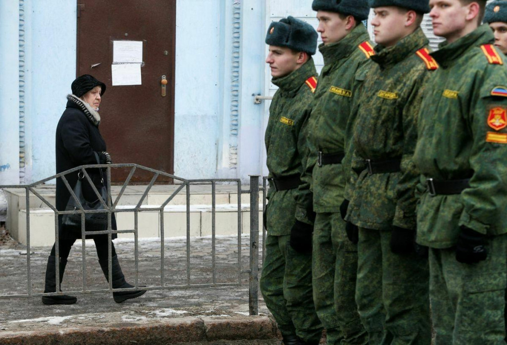 Žena prechádza okolo kadetov samozvanej Doneckej ľudovej republiky v separatistami kontrolovanom meste Doneck. FOTO: Reuters