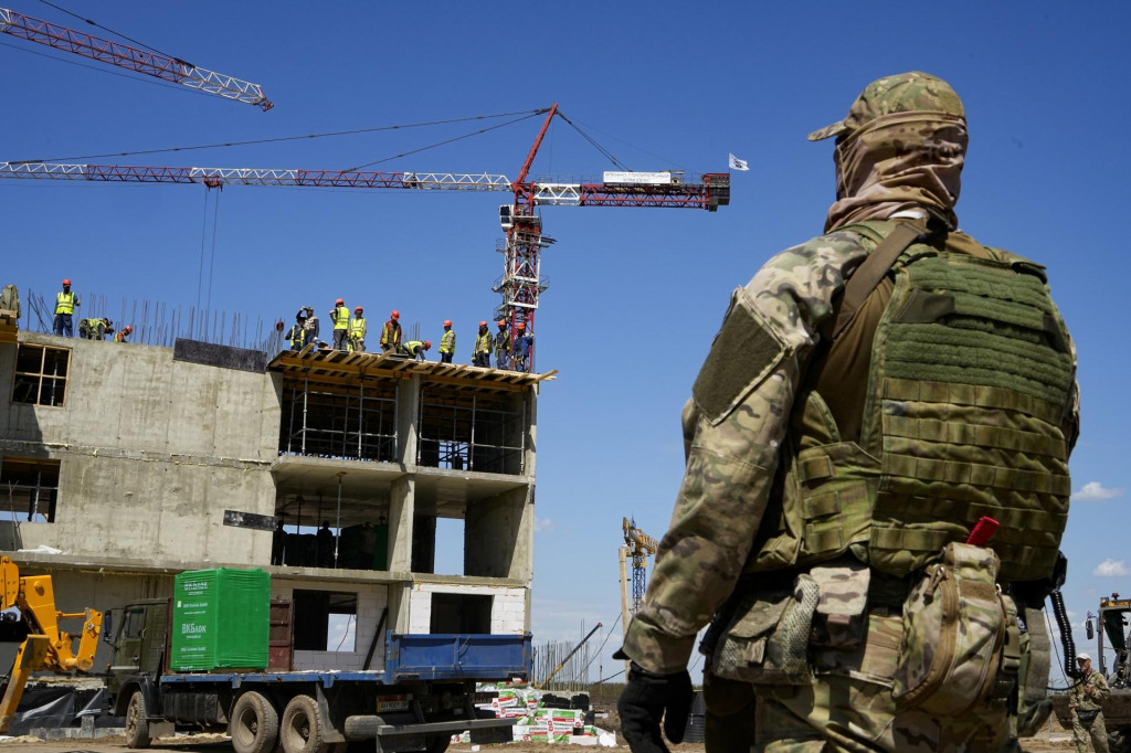 Ruský vojak stráži rozostavanú bytovku, ktorá sa stavia v Mariuopole. Ilustračná snímka: TASR/AP
